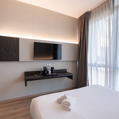 Chambre d'hôtel avec lit confortable et fenêtre donnant sur un jardin verdoyant. Idéale pour les voyages d'affaires Smy.