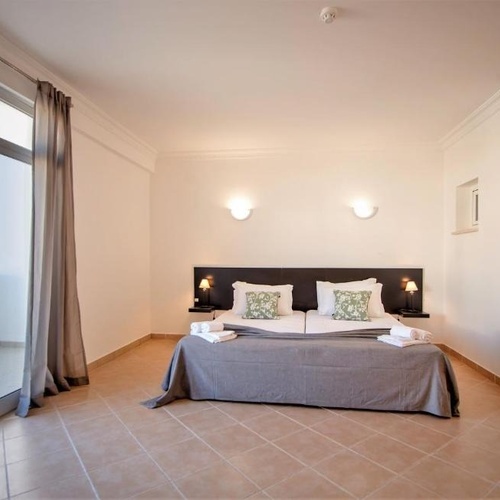 a hotel room with a large bed and a balcony