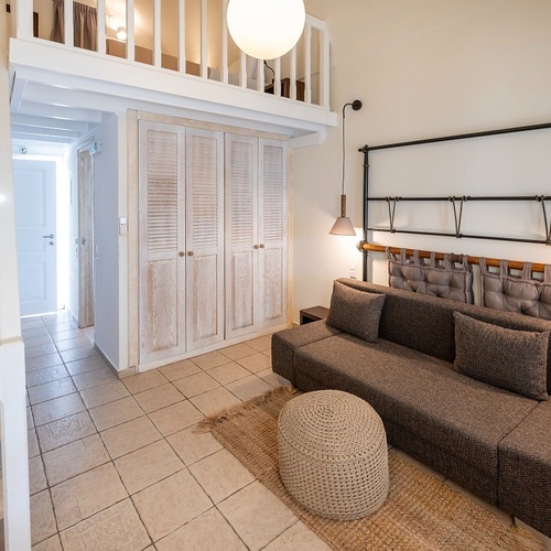 a living room with a couch and stairs leading up to the second floor