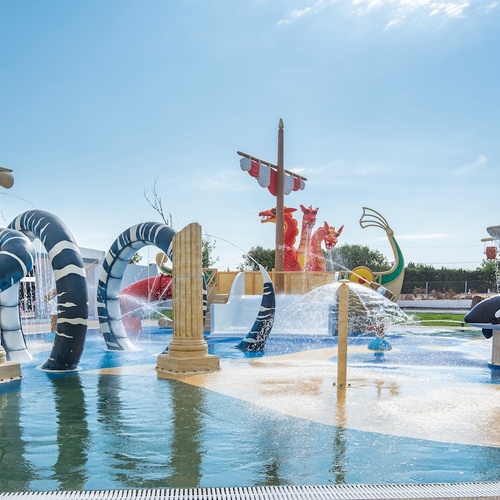 a water park with a pirate ship in the background