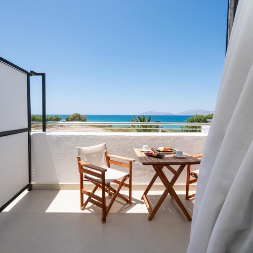 a balcony with a table and chairs and a view of the ocean