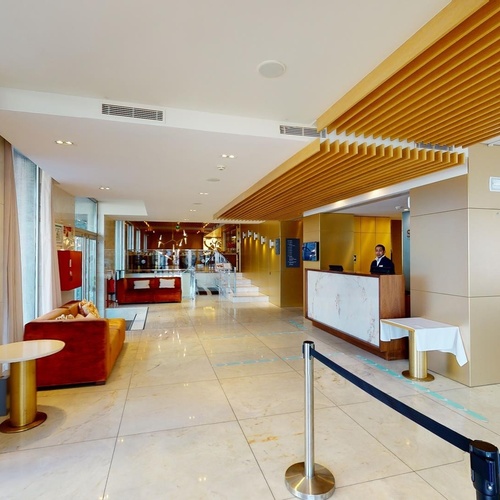 a woman stands at a counter in a hotel lobby