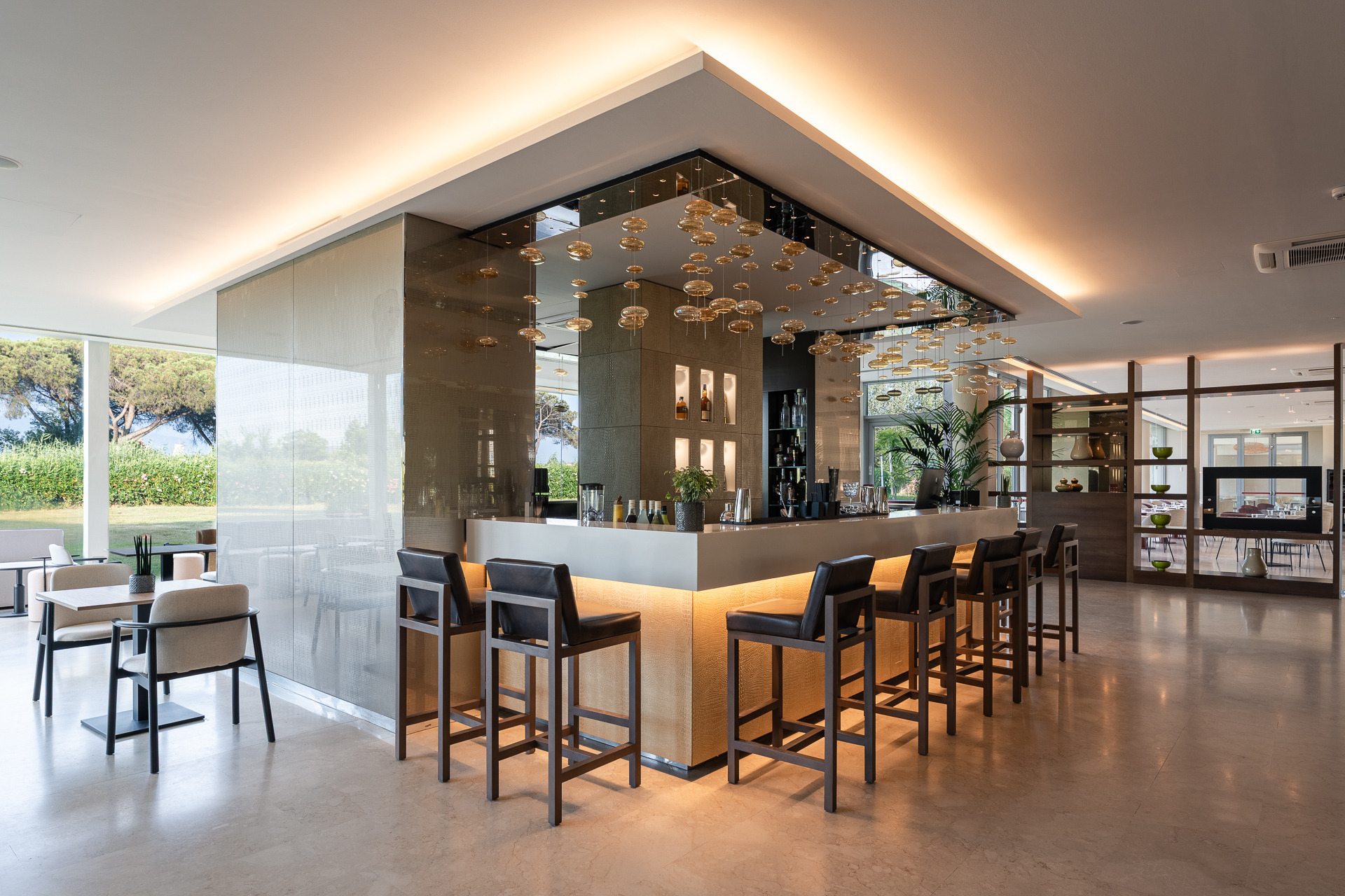 Bar d'hôtel avec tabourets et déco moderne. Smy: Corporate.
