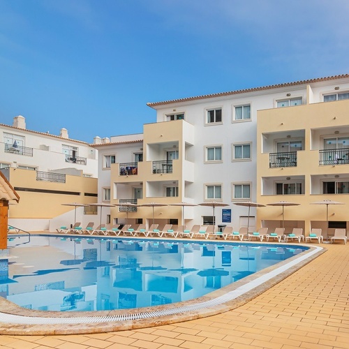a large swimming pool is surrounded by chairs and umbrellas