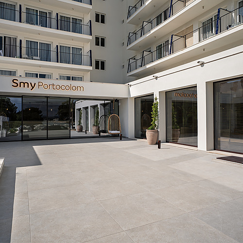 Stylish Smy: Corporativa hotel lobby with central olive tree and circular seating.