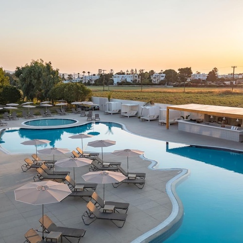 a large swimming pool surrounded by chairs and umbrellas