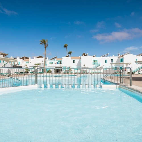 ein Hotel mit einem großen Swimmingpool und vielen Sonnenschirmen