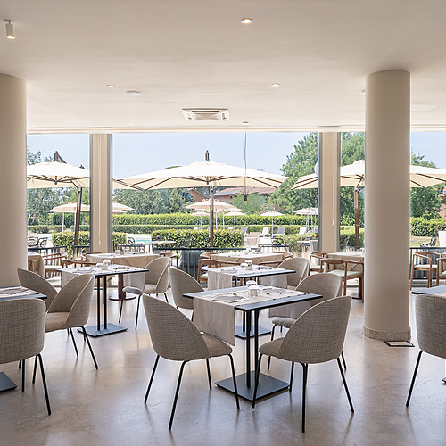 Salle à manger intérieure avec vue sur l'extérieur et des tables dressées pour des repas au Smy: Corporativa.