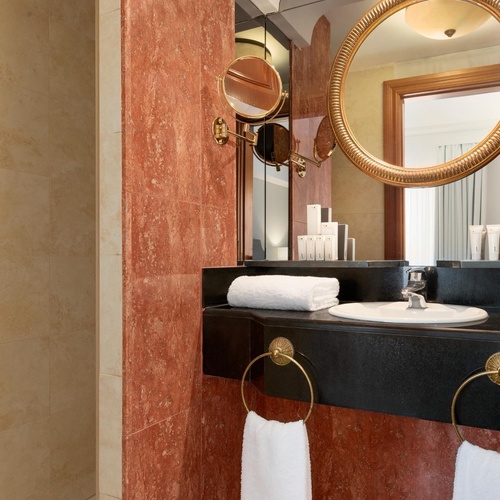 a bathroom with a sink and a round mirror