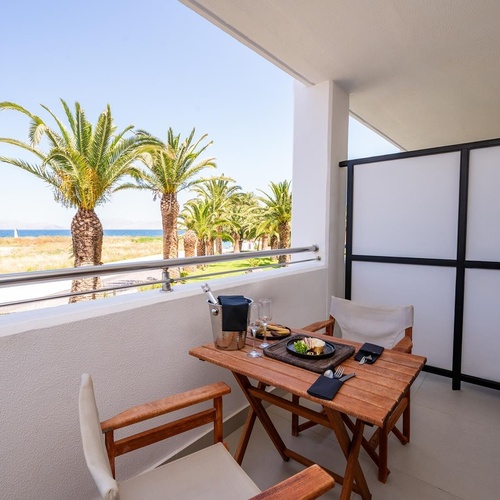 a balcony with a table and chairs and a view of the ocean