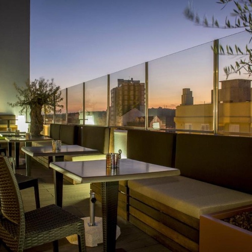 a patio with tables and chairs and a view of the city