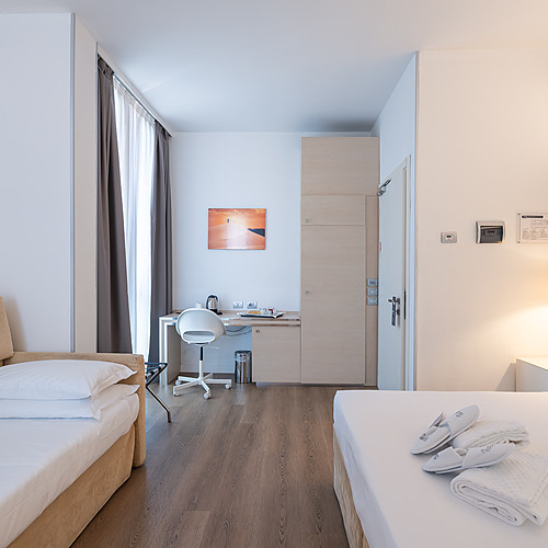Chambre d'hôtel avec lit, bureau et salle de bain accessible. Smy: Corporativa.