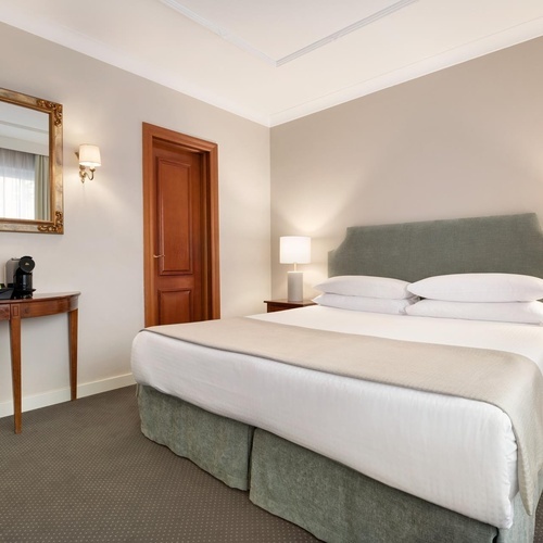 a hotel room with a bed and a mirror