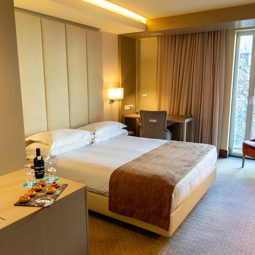 a hotel room with a large bed and a chair