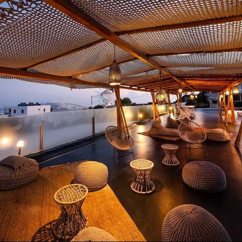 a patio area with chairs and tables under a canopy