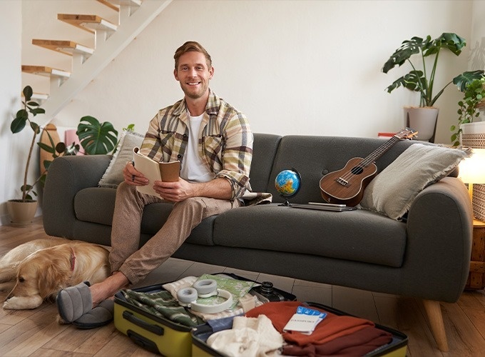 a woman sitting on a couch holding a cell phone and giving an ok sign
