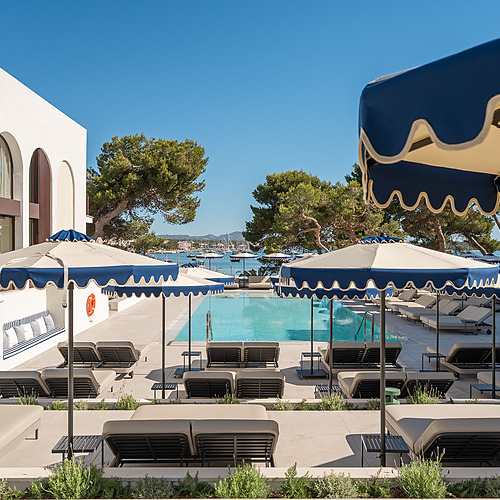 Modern hotel pool with sun loungers and Smy: Corporativa lounge area.
