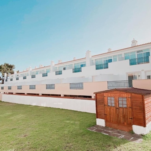 a wooden shed sits in front of a row of houses