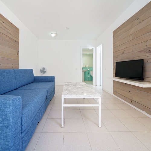 ein Wohnzimmer mit einer blauen Couch und einem weißen Tisch