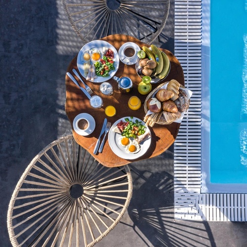 ein Tisch mit Essen und Getränken neben einem Swimmingpool