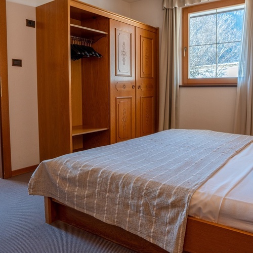 a bedroom with a bed and a wardrobe and a window