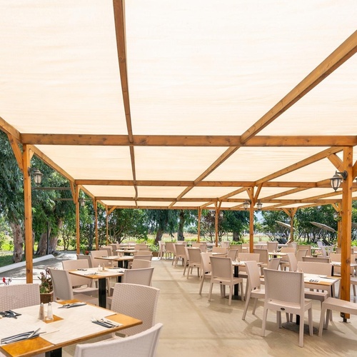 a restaurant with tables and chairs under a canopy