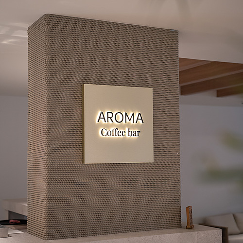 Stylish Smy: Corporativa hotel lobby with central olive tree and circular seating.