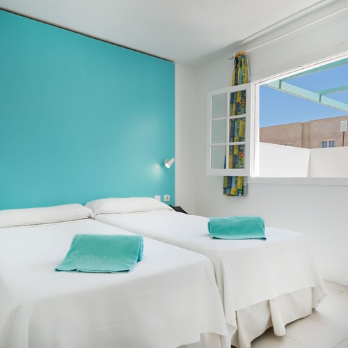 ein Schlafzimmer mit zwei Betten und einer blauen Wand