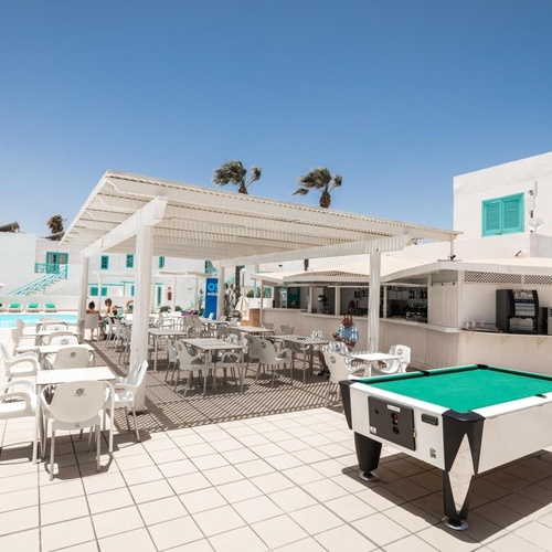 ein Pooltisch steht neben einer Bar und einem Swimmingpool