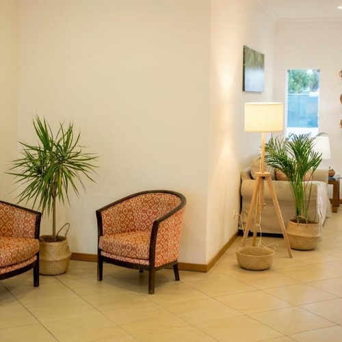 a living room with two chairs and a lamp