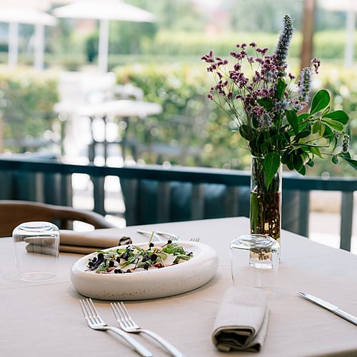 Table dressée pour un repas à l'extérieur, avec un saladier et des fleurs, idéal pour votre séjour à l'hôtel Smy: Corporativa.