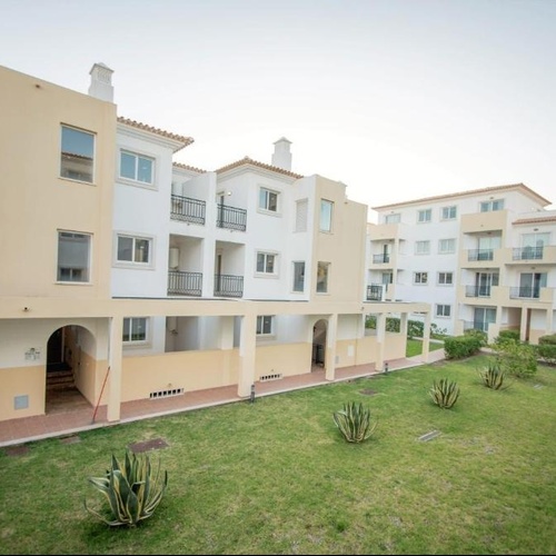 a row of apartment buildings with a lawn in front of them
