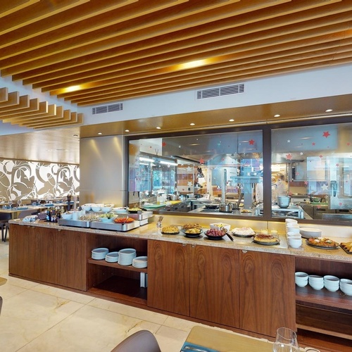 a restaurant with a buffet and a kitchen in the background