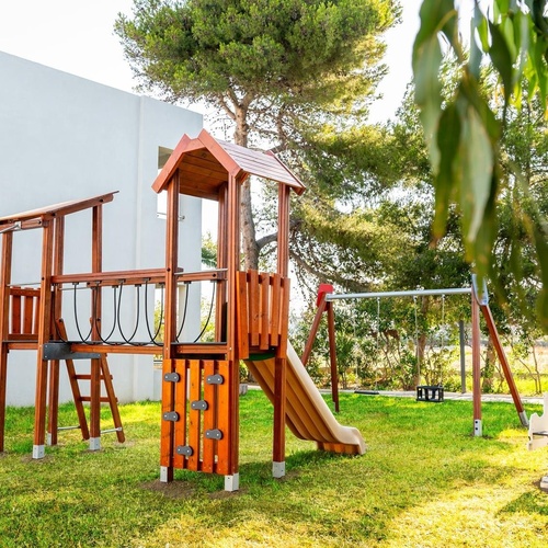 a wooden playground set with a slide and swings