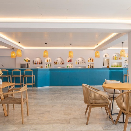 a restaurant with tables and chairs and a blue bar