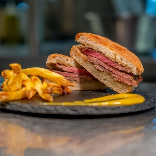 a sandwich and french fries on a black plate