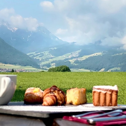 a tray of pastries and a cup of coffee with a mountain in the background
