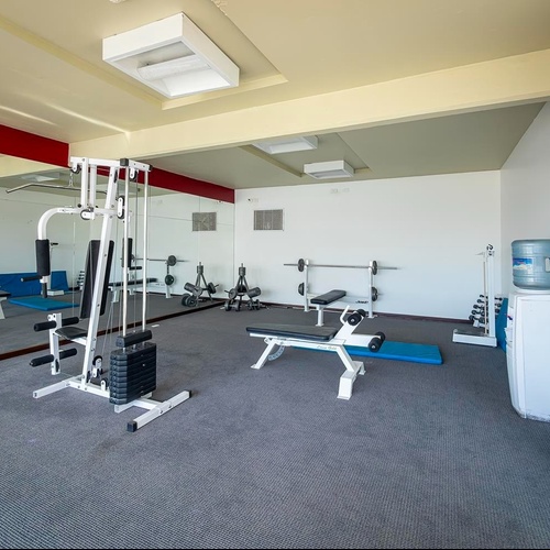 Una lounge interna accogliente e rustica, arredata con mobili in legno, divani e poltrone imbottite, e una parete in pietra.