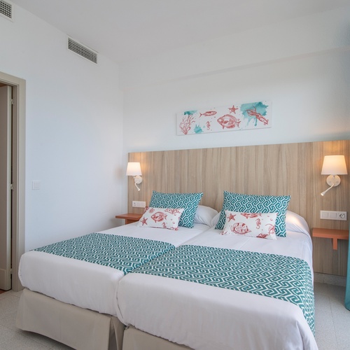 um quarto de hotel com duas camas e uma pintura sobre a cabeceira