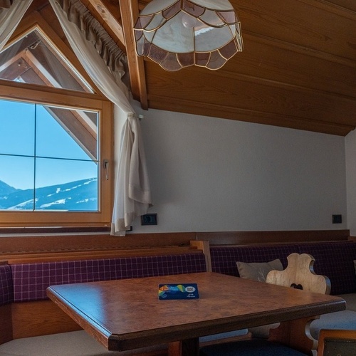 a room with a table and a window with mountains in the background