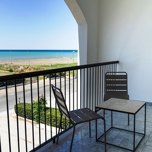 ein Balkon mit zwei Stühlen und einem Tisch mit Blick auf den Ozean