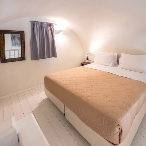 a bedroom with a bed and a mirror on the wall