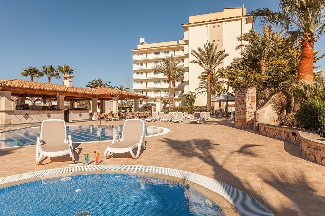 ein Hotel mit einem Pool und Liegestühlen davor