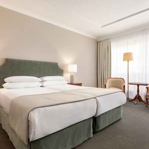 a hotel room with two beds and two chairs