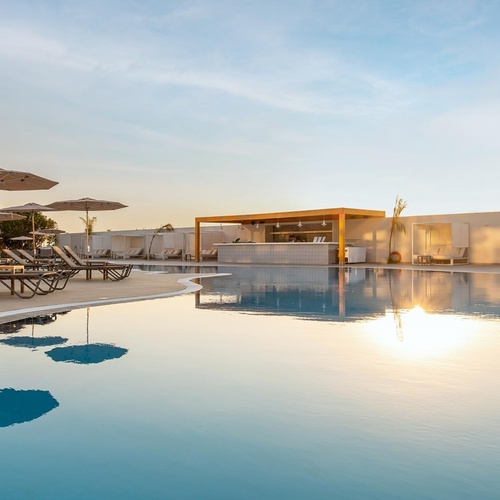 a large swimming pool with umbrellas and chairs around it