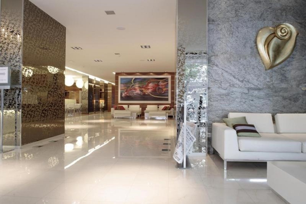 a living room with a white couch and a painting on the wall