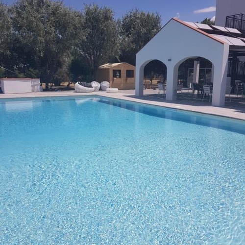 ein großer Pool mit einem weißen Gebäude im Hintergrund