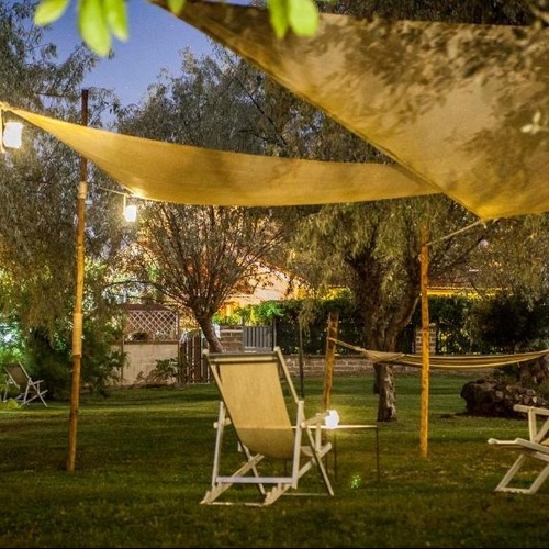 Liegestühle und Hängematte unter einem Zelt in einem Garten