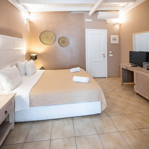 a hotel room with a large bed and a painting on the wall