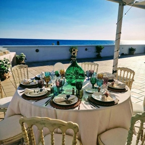 ein Tisch mit Tellern und Gläsern und einer grünen Flasche auf dem Tisch
